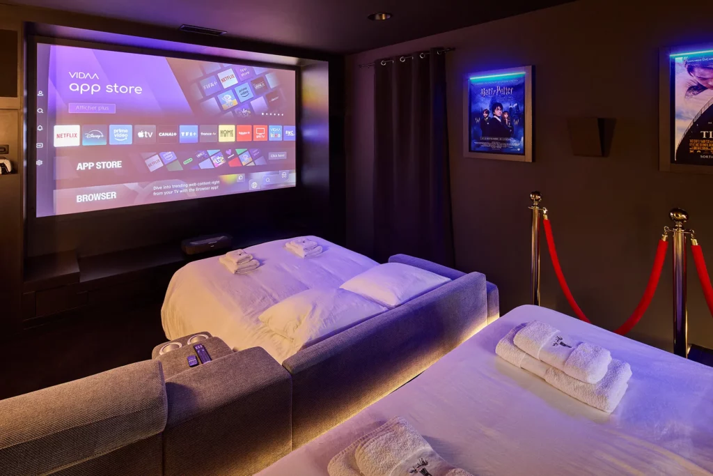 Love room Niort avec écran cinéma géant et lit douillet pour une soirée romantique.