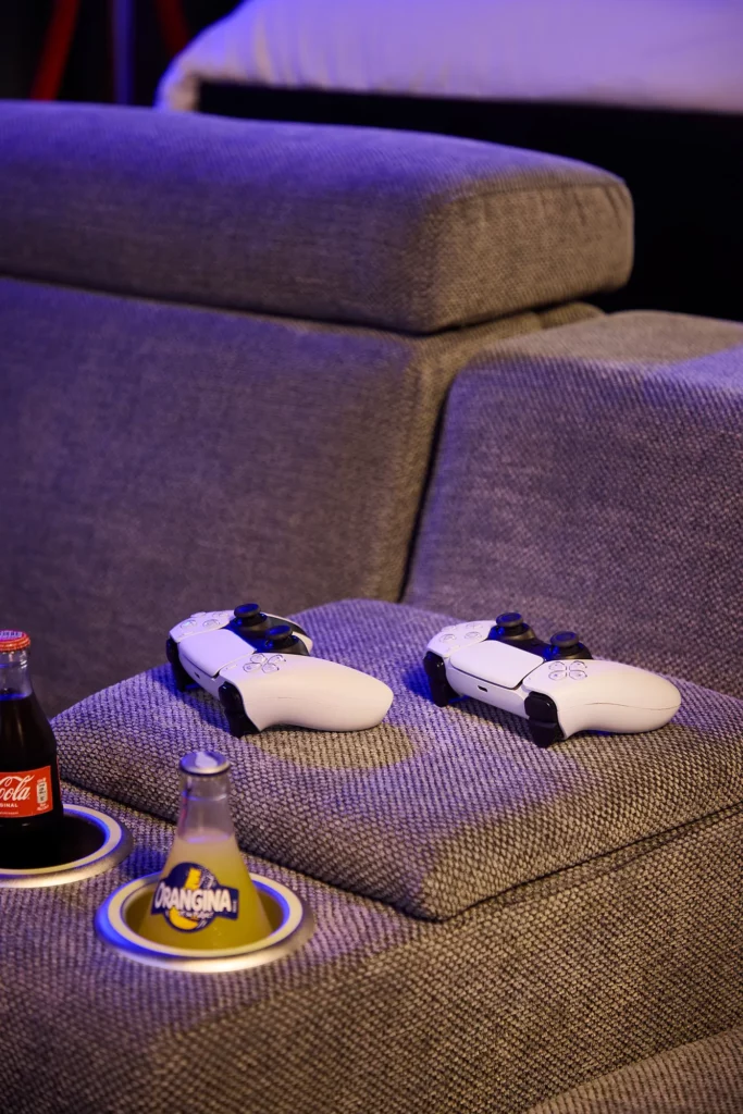 Manettes de PS5 sur le canapé – Ciné Room