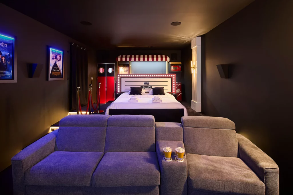 Fauteuils club et grand écran, le luxe d'une love room Niort chez Atypique Room.